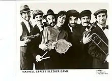 People lined up with instruments are posing in a black and white photo