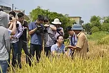 Vietnamese farmers surrounded by photographers