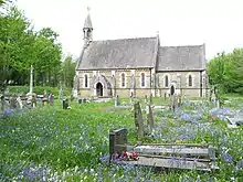 Merthyr Mawr Church. The medieval cross is to the left of the church
