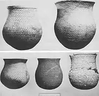 A black and white picture of several large ceramic vessels