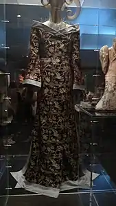 A dress by Alexander McQueen in the style of a traditional Chinese clothing; the gown is exhibited alongside Han dynasty ceramic figures