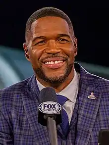 Michael Strahan holding a microphone