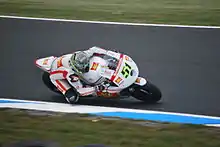 Rider during a right turn on a white painted racing motorcycle