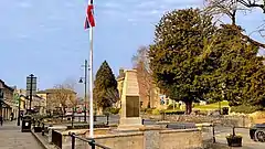 A war memorial over the river with the street in the background