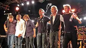 Mike + The Mechanics in concert in July 2012L-R: Ben Stone, Andrew Roachford, Tim Howar, Luke Juby, Mike Rutherford and Anthony Drennan