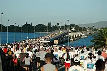 Hundreds of runners at the start line of a marathon at the O'ahu side of the Admiral Clarey bridge.