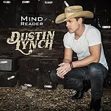 Lynch is wearing a white t-shirt, black jeans and cowboy boots, and a straw cowboy hat while squatting. The song title is colored white and below it is the artist's logo colored beige.