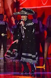 singer in charro outfit singing.