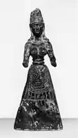 Baltimore stone figure, probably a fake, pre-1929.  A snake winds round the headdress and the hands are pierced as if to hold snakes.