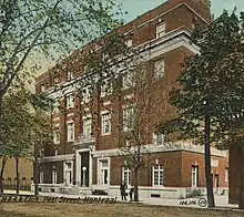 Postcard image of the building's exterior clad in red bricks with white trim around the doors and windows