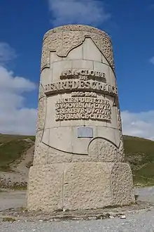 A cylindrical stone monument with the an inscription inside by an outline of France