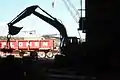 Excavator moving heavy machinery parts with a magnet.