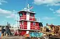 A barge ready to salvage heavy machinery parts and a tugboat named Miss Susan.