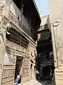 The raised passage linking the main building (right) and the annex (left). The annex consists of a hod (water trough for animals) on the ground floor and a kuttab (school) on the upper level.