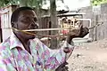 Mozambique, 21st century. Man playing a heterochord musical bow, using his mouth for a resonator.