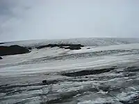 A continuous mass of glacial ice protruded by a few rock outcrops