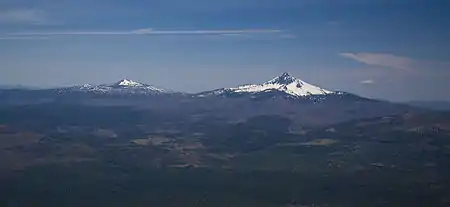 The smaller Belknap formed on the lower slopes of the larger Mount Washington, which is larger in size and height