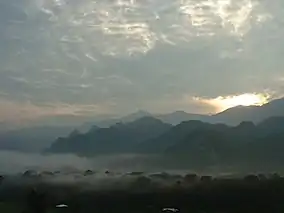 Sunset or sunrise over a mountain landscape with fog in the valleys.