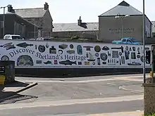 A mural with the text "Discover Shetland's Heritage" and images of archaeological and craft objects