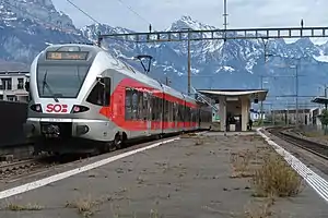 Silver and red train next to island platform