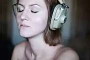 Woman listening privately to music through headphones (Russia, 2010)