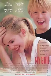 A girl holding her hand on her head and laughing, and a boy laughing in the background