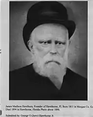 Photo of an older, bearded man wearing a dark hat