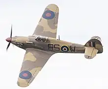 Propeller-driven fighter aircraft in flight with Royal Air Force markings from World War II.