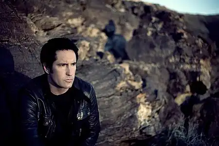 A man sitting in front of a field of craggy rocks