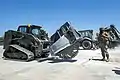 US Navy skid steer with wheel saw attachment