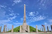 Haraldshaugen Monument is a stone column on a hill raging into the blue sky