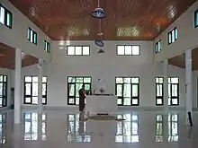 The first floor of the Mountain meditation hall, with a white marble Buddha statue in front. The floor and walls are white coloured.