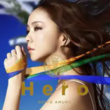 A close-up image of Namie Amuro's face, holding ribbons that resemble the Brazilian flag. A blue wallpaper is present in the background.