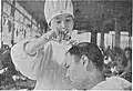 A nurse cuts the hair of an injured soldier
