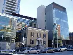 Downtown skyline with a small brick house inside a number of high rises