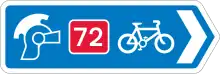 Blue traffic sign with a Roman helmet icon, a white bicycle symbol and a red square with the number 72 in it.