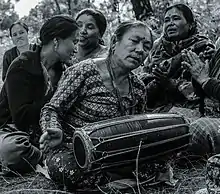 Nepalese woman playing madal in a social gathering