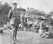 Unarmed soldiers and officers rest behind a ridge