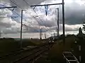 Masts in place for the future 25 kV overhead wires at Bourdigny looking toward Satigny.  A Geneva bound FLIRT has just left Satigny