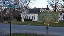 a picture of the marker with a white building, possibly the tavern itself, behind it