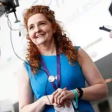 A Woman in blue with lanyard at a conference