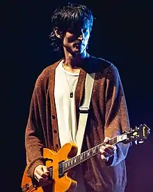 Valensi playing guitar.