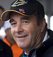 Nigel Mansell wearing a black baseball cap with the number 5