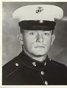 A black and white headshot photo of Noonan in his military dress blue uniform with hat.