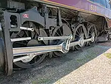 A close-up of a large steam locomotive's driving wheels