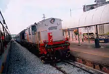 White diesel engine pulling a passenger train