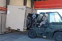 A forklift of the 119th Logistics Readiness Squadron maneuvers a Disaster Relief Beddown Set (DRBS) container into position while preparing it for shipping at North Dakota ANGB during September 2017.