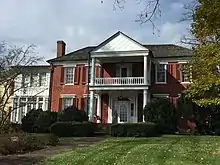 red brick two-story large house with double porch