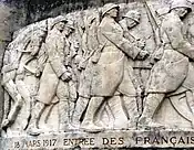 The relief on the Noyon war memorial commemorating the re-entry of the 13th Army Corps on 18 March 1917