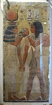 Relief of Hathor holding a man's hand and lifting her menat necklace for him to grasp